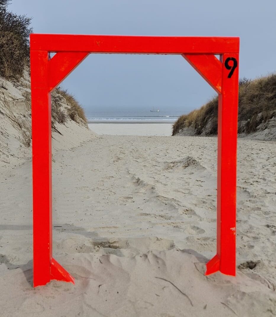 kleines neonoranges Tor am Strandabgang